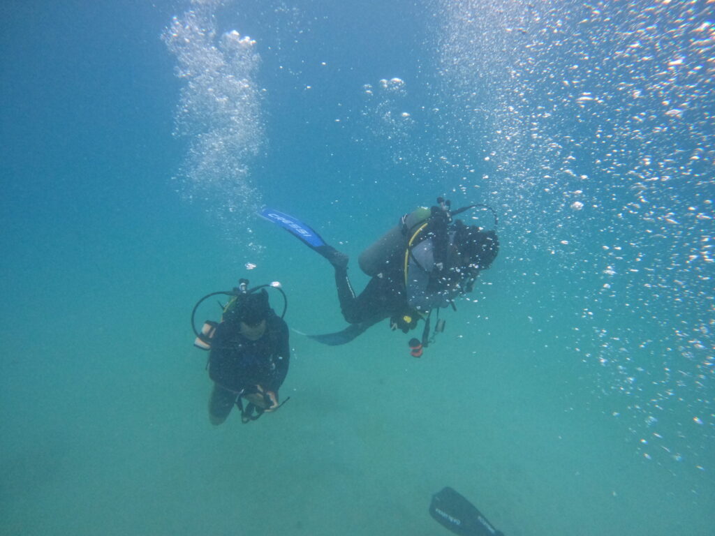 A Padi Divemaster student removing their mask at neutral buoyancy.